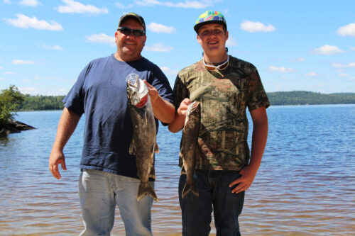 Father and Son Showing Off Lake Trout Catches