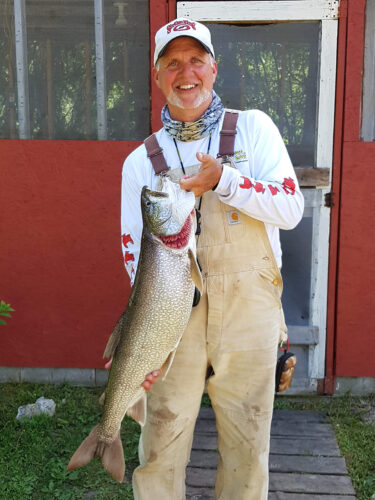 guest holding huge lake trout catch