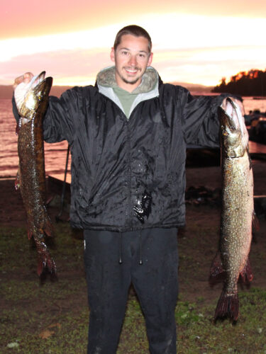 Guest Holding Two Huge Northern Pike Catches