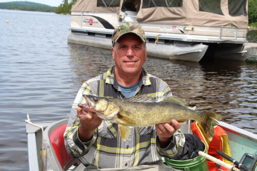 Guest Holding Walleye Catch in Boat