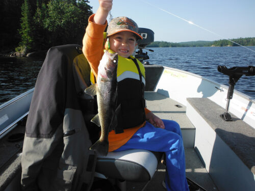 kid holding fishing line with walleye