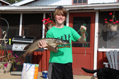 young boy with his northern pike catch
